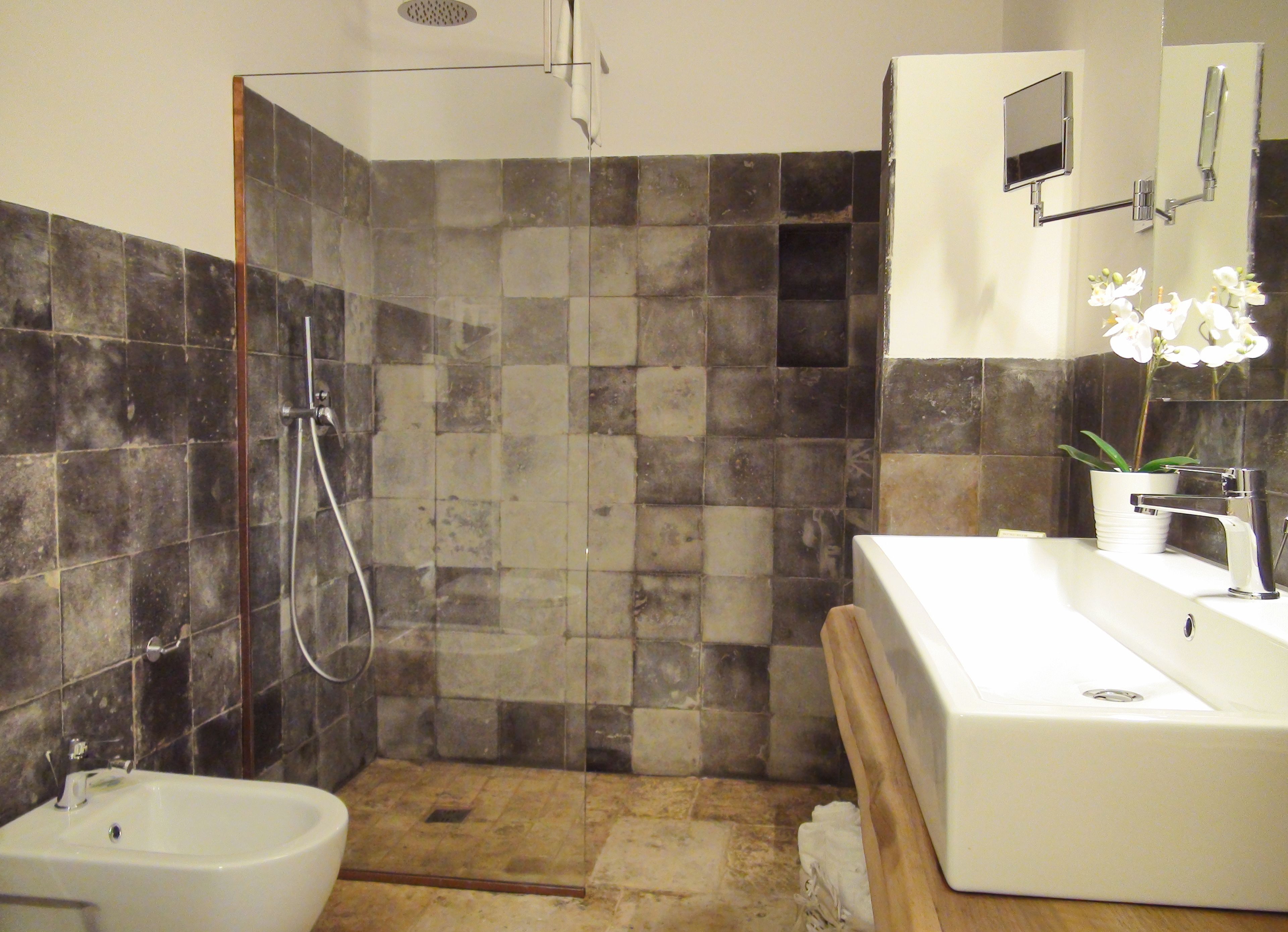 Un baño moderno con ducha de vidrio, una bañera independiente y un espejo grande sobre el lavabo.