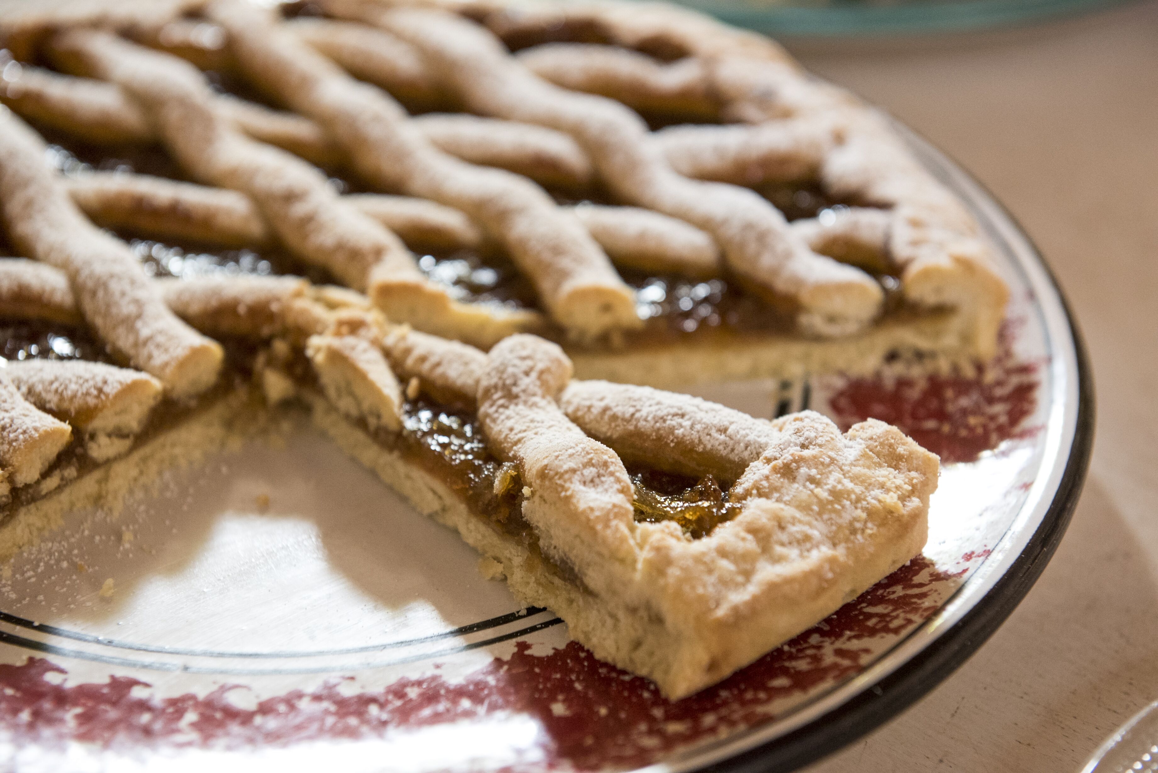 A pie with a lattice crust on a glass plate.
