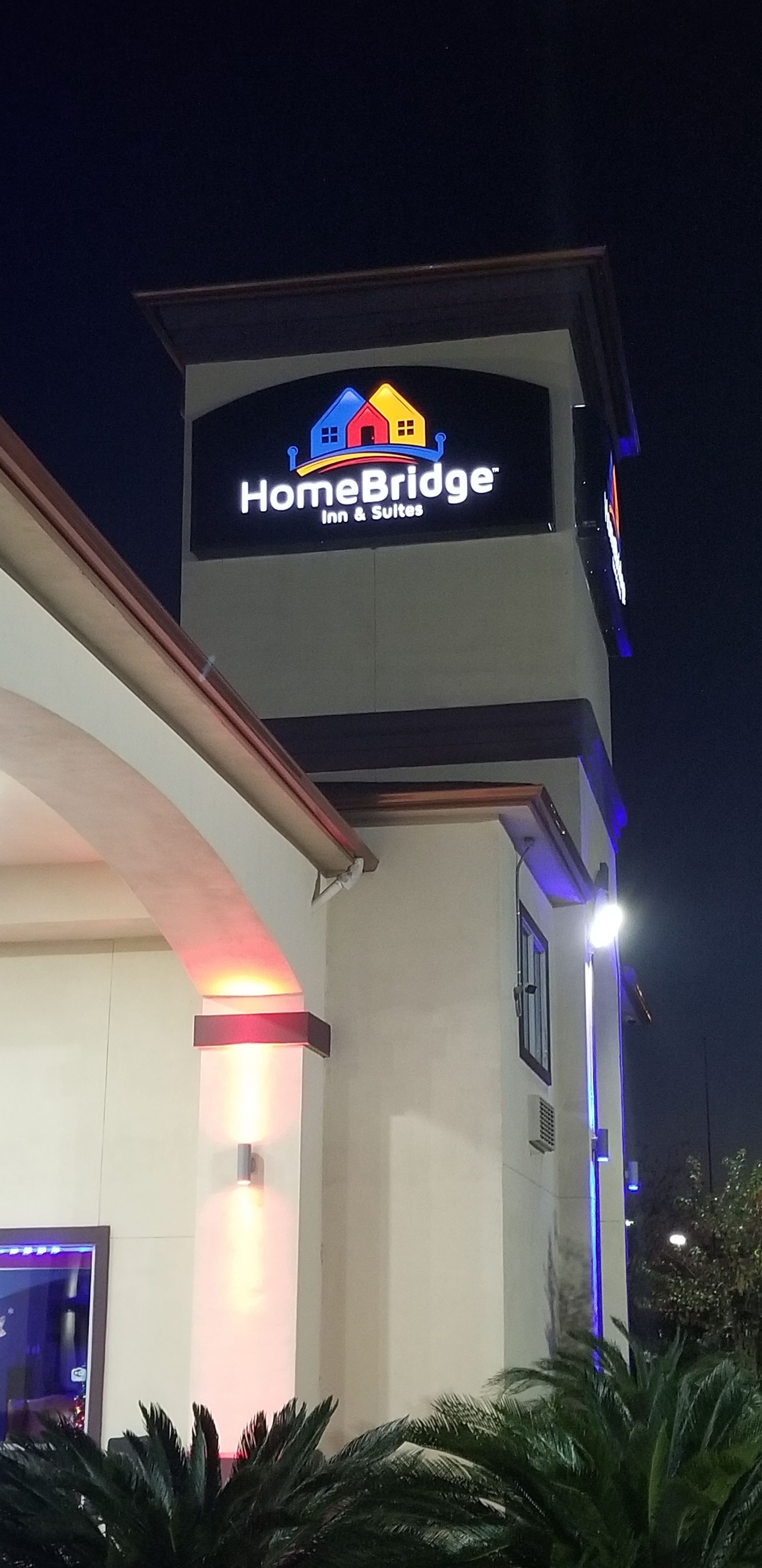 A building with a sign that reads "HomeBridge Inn & Suites".