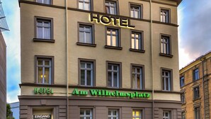 A hotel building with multiple windows and a sign that reads "HOTEL Am Wilhelmplatz." - Hotel am Wilhelmsplatz (Stuttgart)