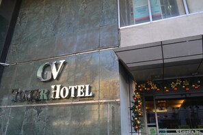 The exterior of the GV Tower Hotel with a prominent sign.