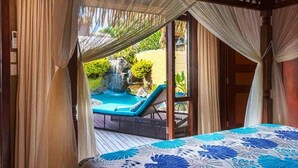 A bedroom with a view of a hot tub and waterfall. - Rumours Luxury Villas & Spa (Rarotonga)