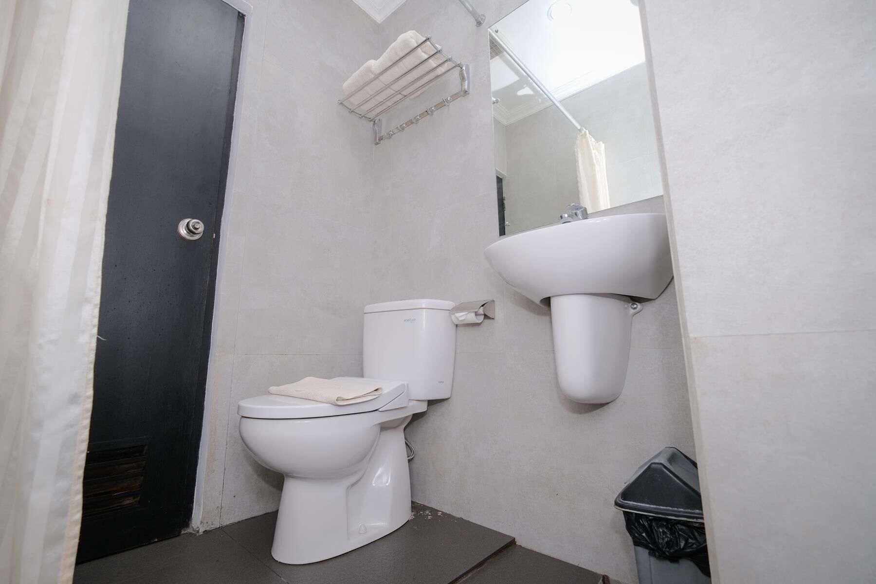 A bathroom with a toilet, a sink, and a shower area.