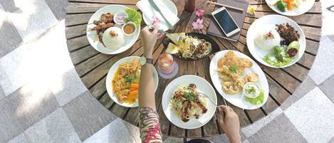 A circular wooden table with various dishes and a smartphone.