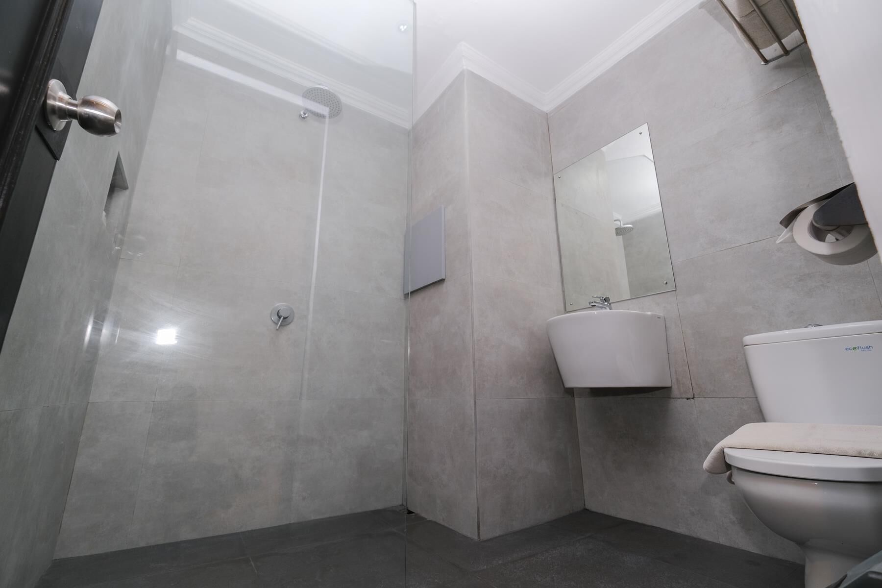 Un bagno moderno con doccia, lavandino e WC.
