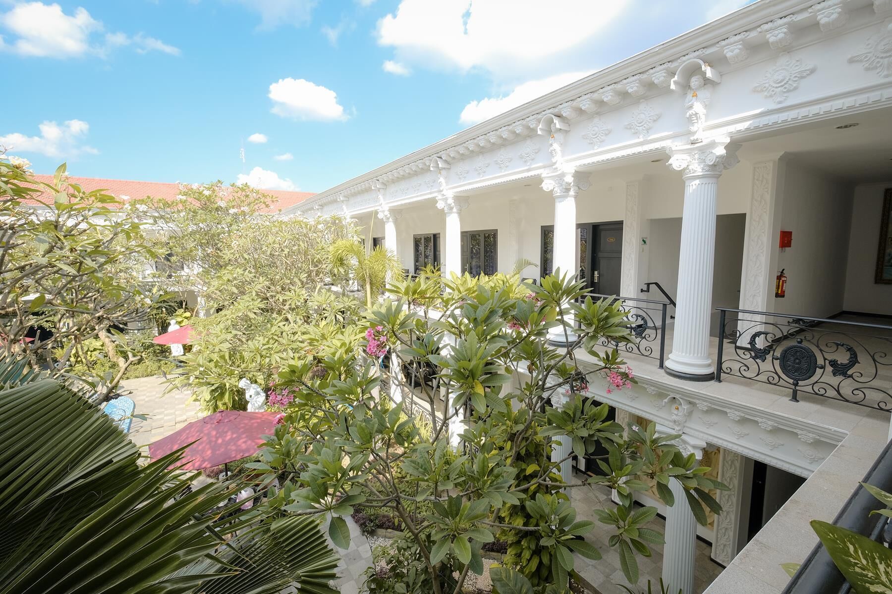 A building with white columns and a balcony with metal railings.