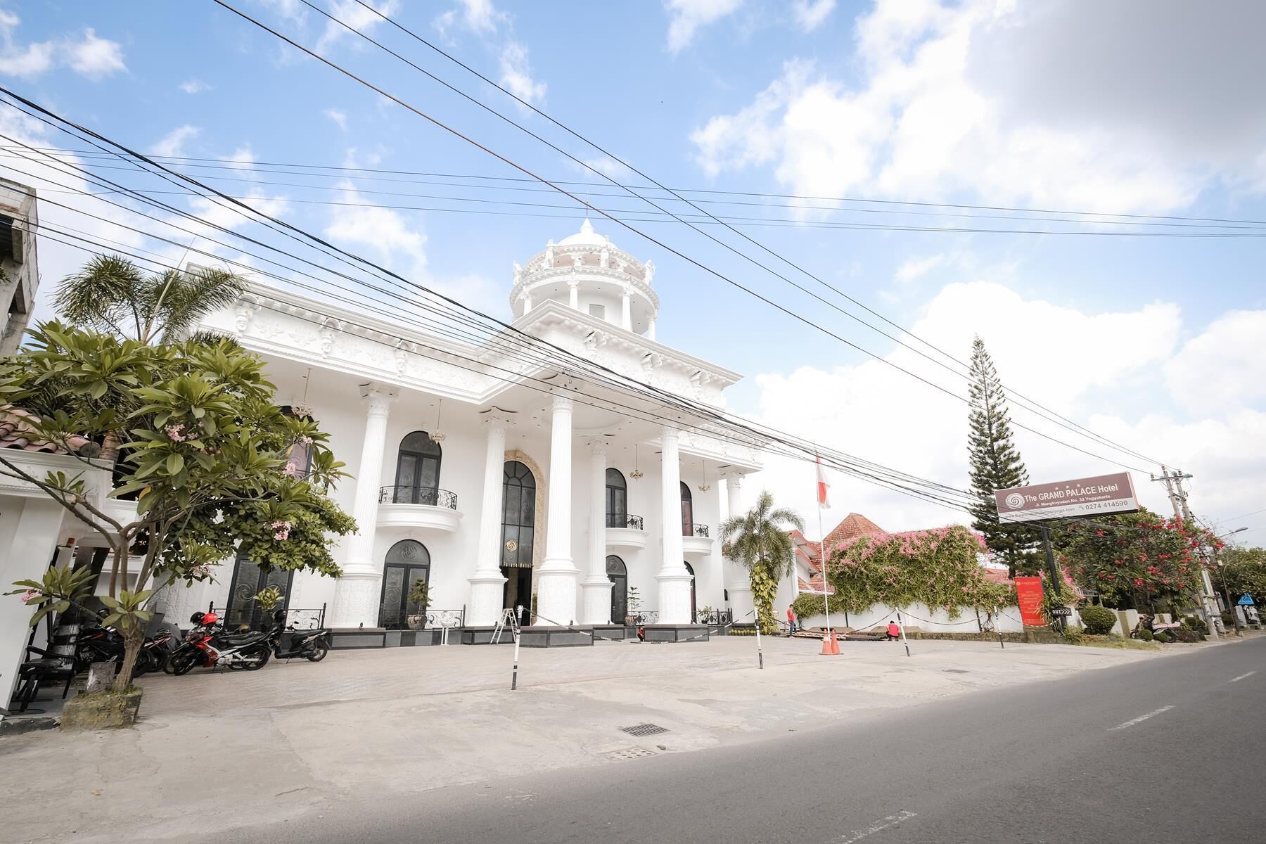 A grand, white colonial-style building with a prominent dome and columns, likely a hotel.