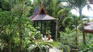 A gazebo with a red roof surrounded by lush greenery and palm trees. - Villa Del Porto (Langkawi)