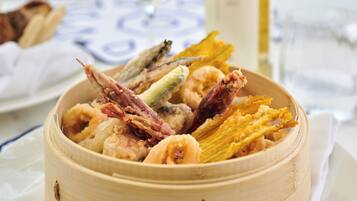 A bamboo steamer filled with various fried seafood items.