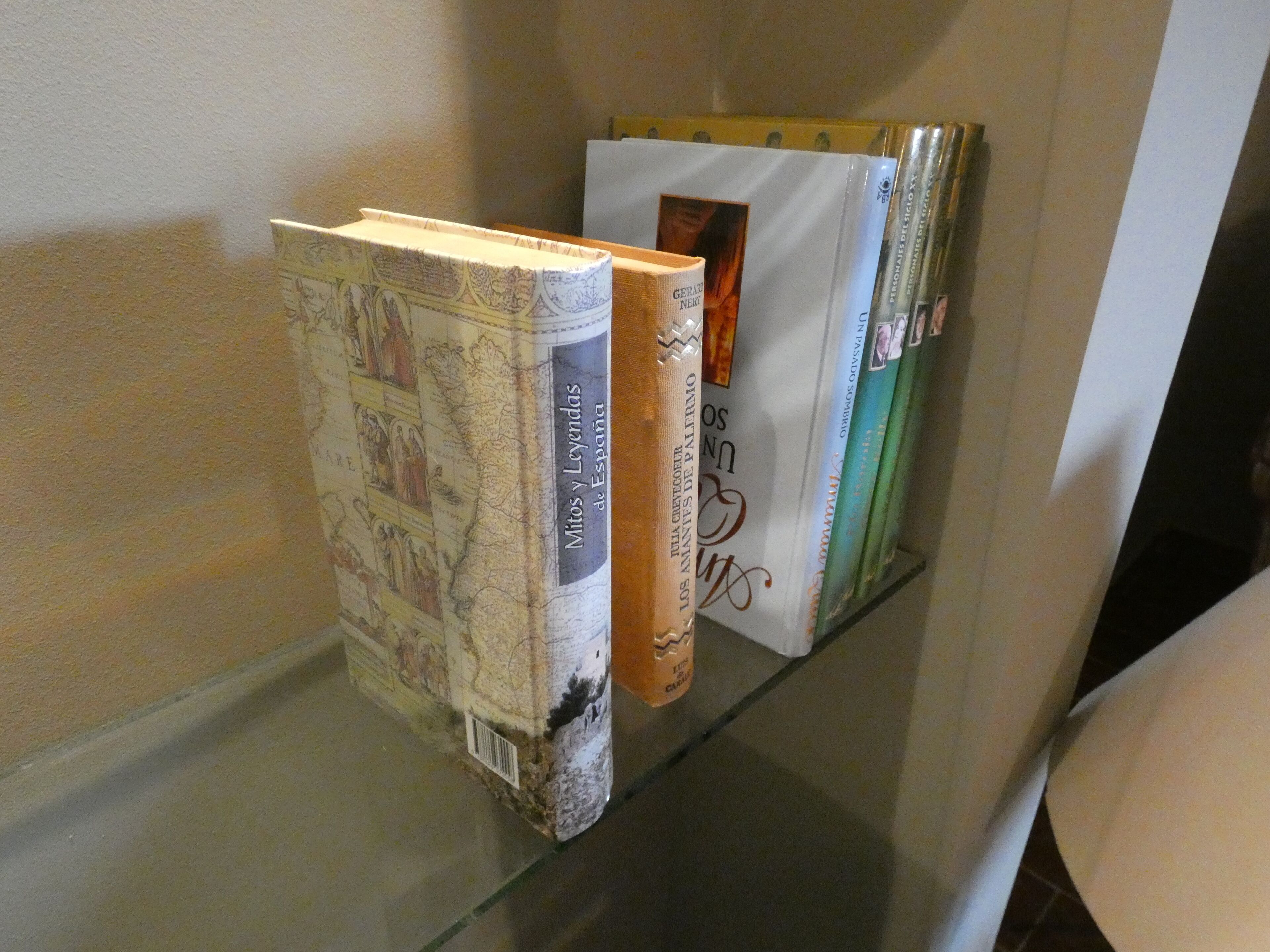 A bookshelf with books, including titles like 'Mitos y Leyendas de España' and 'Los Anales de Palerm'.