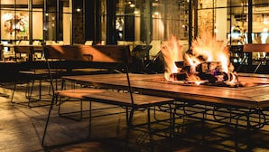An outdoor seating area with a fire feature, tables, and chairs. - Rock Noir Hôtel & Spa (La Salle-les-Alpes)
