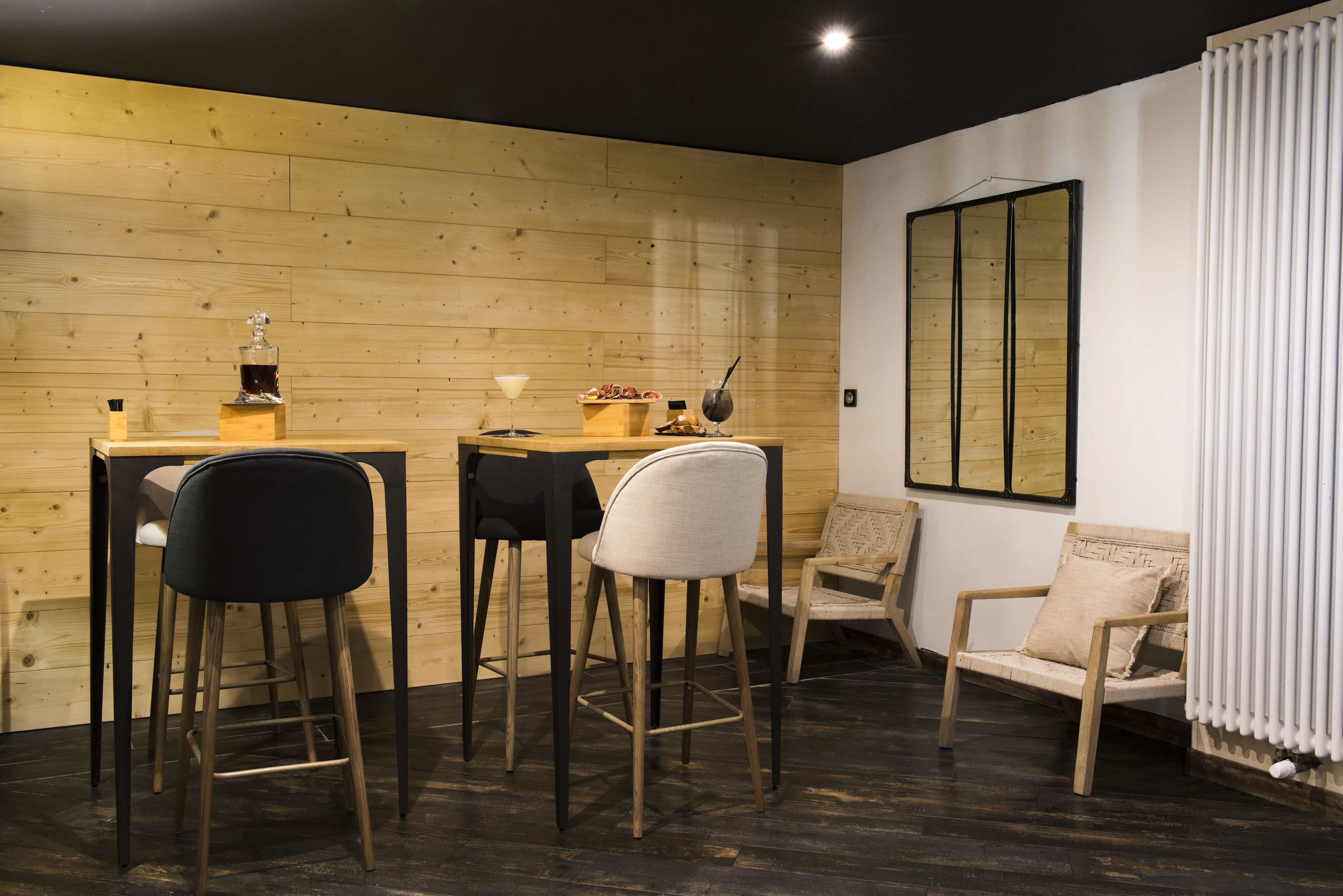 A cozy dining area with wooden walls, a bar counter, and two chairs.