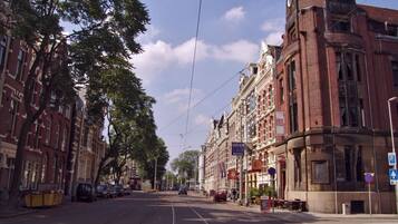 A street with tram tracks, historic buildings, and a clear sky.