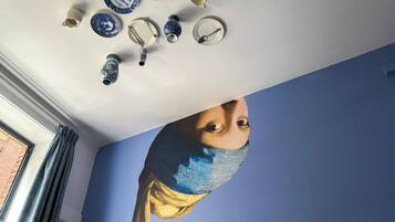 A room with a blue wall and a ceiling with various ceramic items.