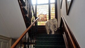 Una escalera con barandillas ornamentadas y una gran estatua de elefante en la parte superior.