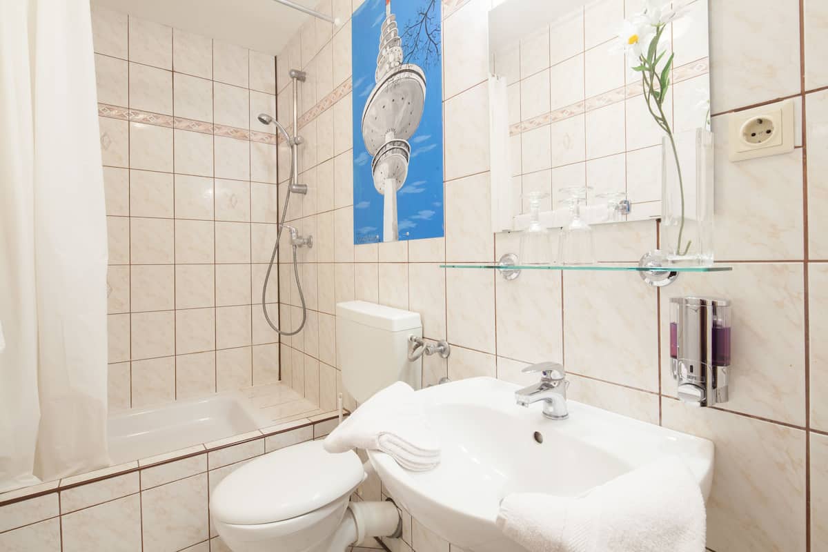 A bathroom with a toilet, sink, and shower.
