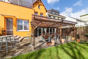 A patio with wooden tables and chairs, a pergola, and potted plants. - Hotel Marco Polo (Hamburg)