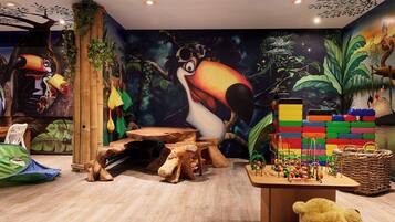 Children's room with a jungle-themed mural, play table, and play tent.