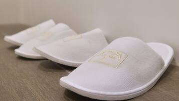 Un par de zapatillas blancas con un emblema dorado en la suela.