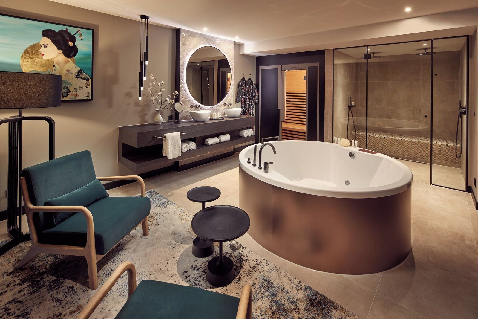 Ein modernes Badezimmer mit freistehender Badewanne, einem Waschtisch mit großem Spiegel und einer Sitzecke mit Stühlen und einem kleinen Tisch.