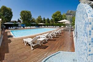 Una piscina al aire libre, sillones reclinables de piscina