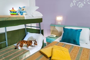 Quarto com beliche, um brinquedo de pelúcia em formato de tigre na cama inferior, mesa de cabeceira com um telefone e mesa de cabeceira com abajur.
