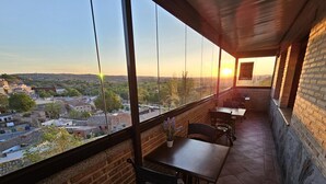 Un balcón con vista a un paisaje urbano al atardecer.