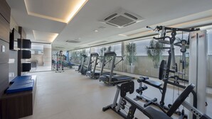 Een moderne sportschool met loopbanden, krachttrainingapparatuur en fitmatten.