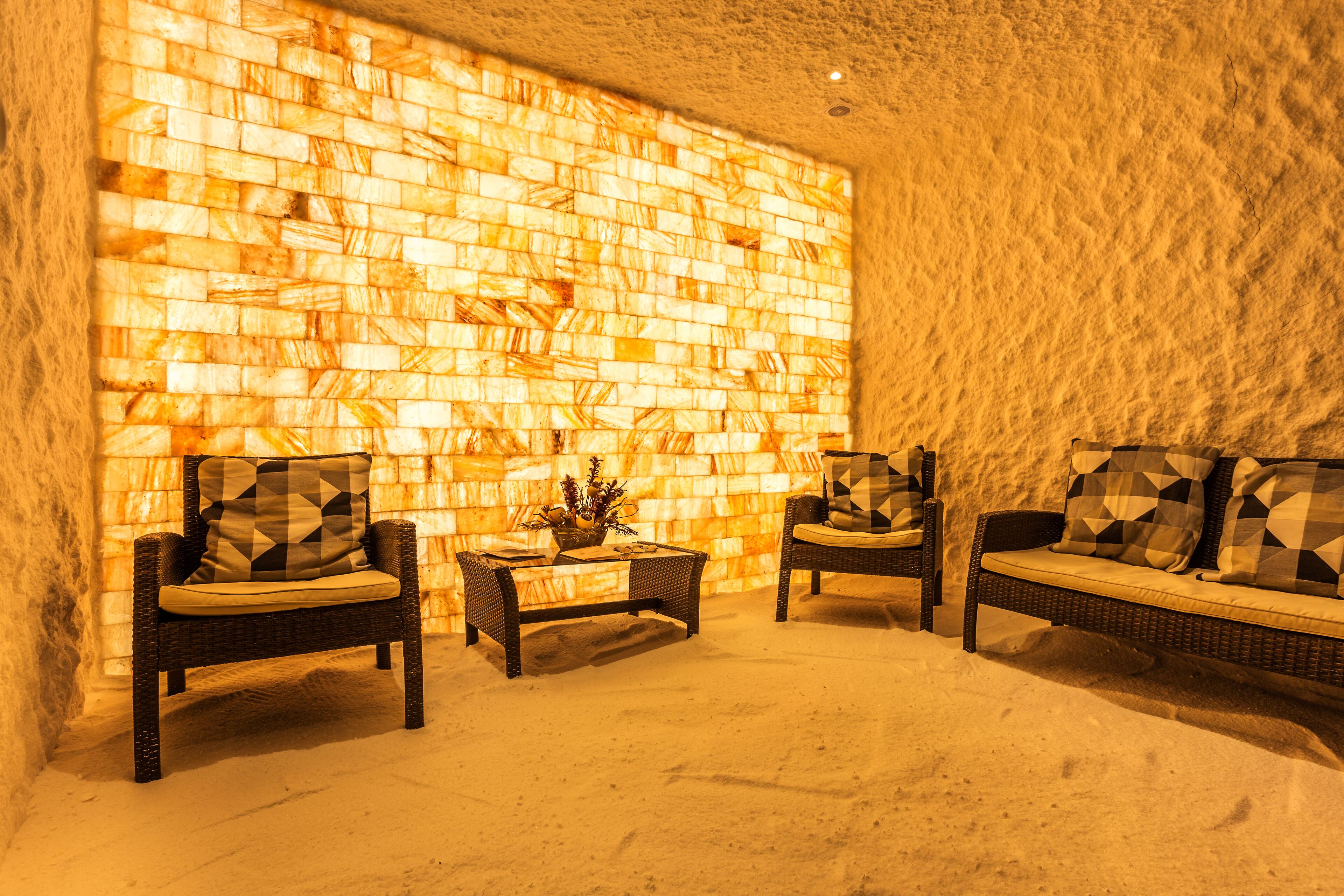 A cozy lounge area with wicker furniture and a textured wall.
