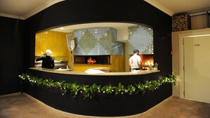 Een keuken met een centraal eiland, een betegelde spatwand en een hangende plantdecoratie.