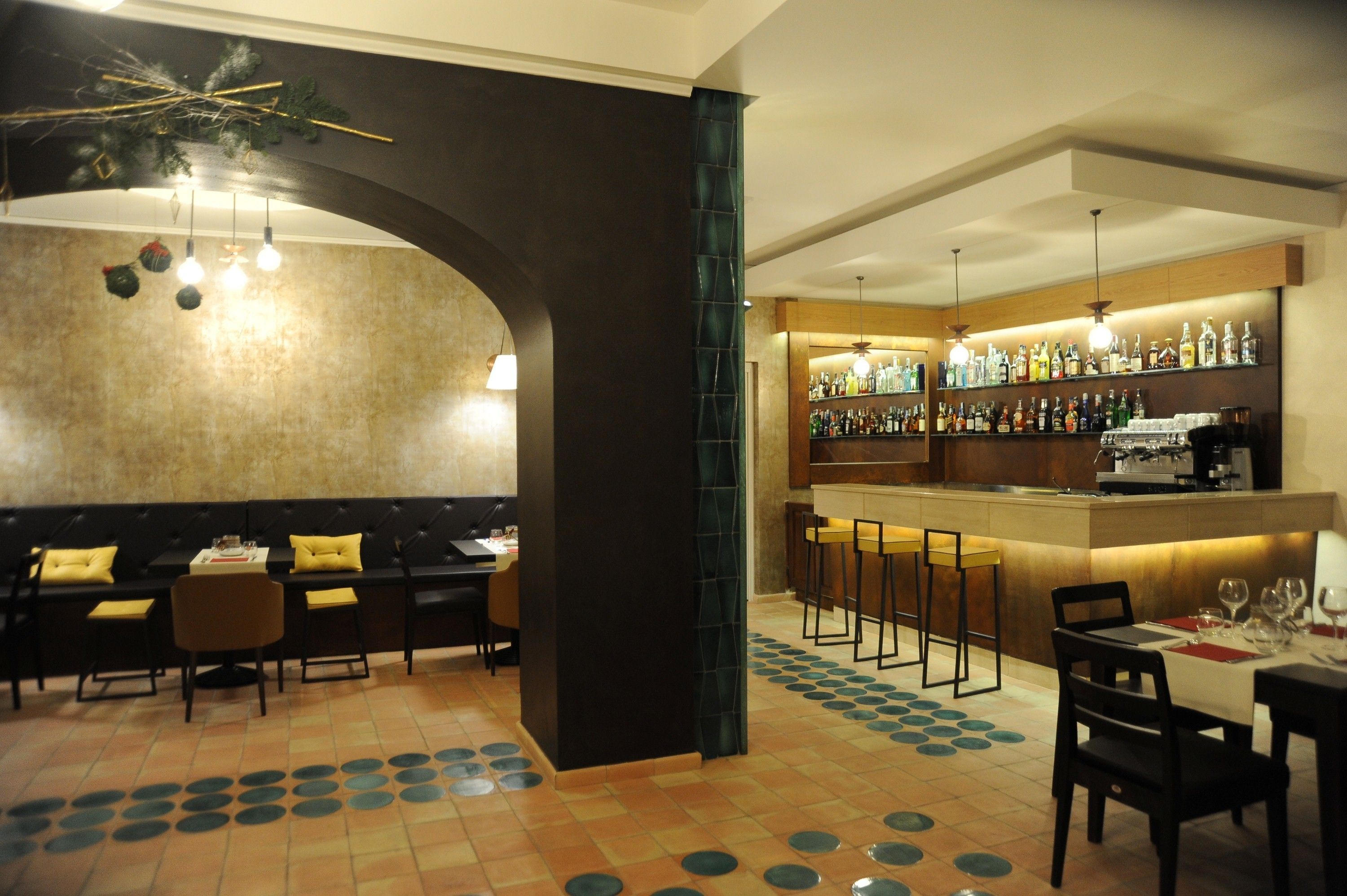 A bar area with a counter, stools, and a seating area with tables and chairs.