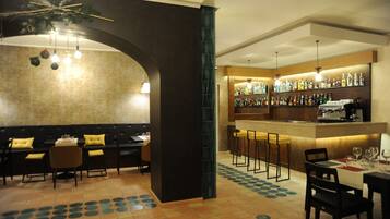 A bar area with a counter, stools, and a seating area with tables and chairs.