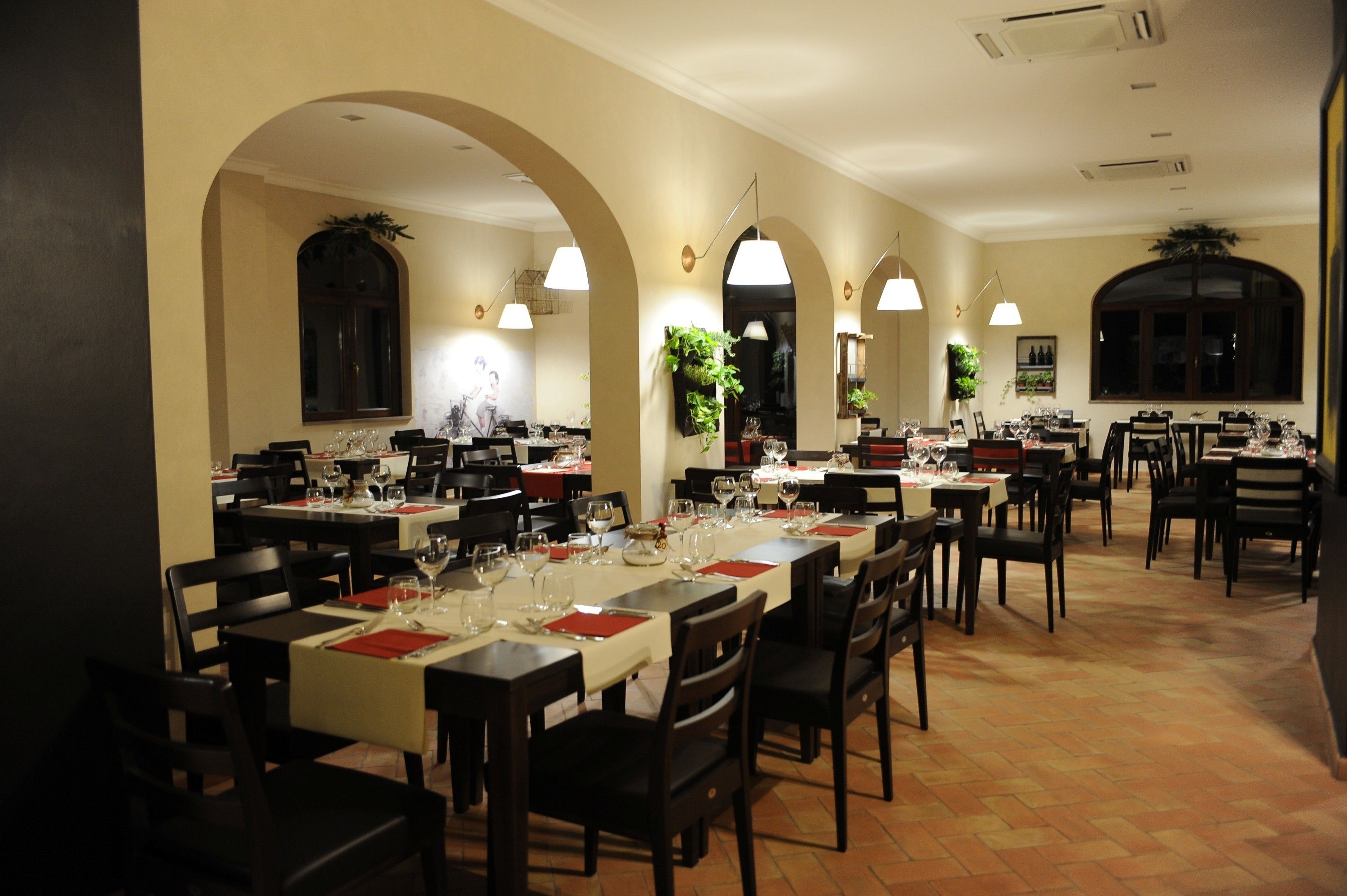 A restaurant with multiple dining tables, chairs, and archways.