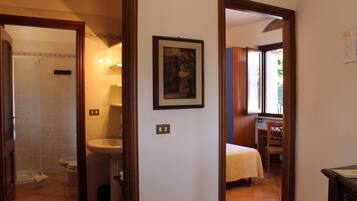 Una habitación de hotel con baño, cama y escritorio.