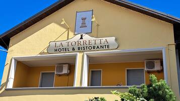 Un edificio con un cartello che recita 'LA TORRETTA HOTEL & RISTORANTE'.