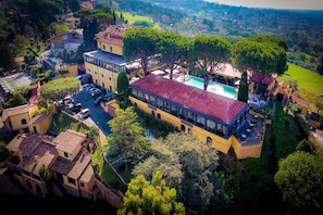 A large villa with a swimming pool, multiple balconies, and lush greenery. - Grand Hotel Helio Cabala (Marino)