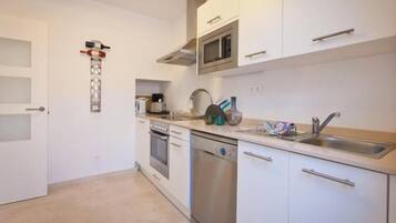 Fridge, microwave, coffee/tea maker, cookware/dishes/utensils