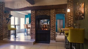 A cozy interior with a brick fireplace, yellow chairs, and a blue accent wall.