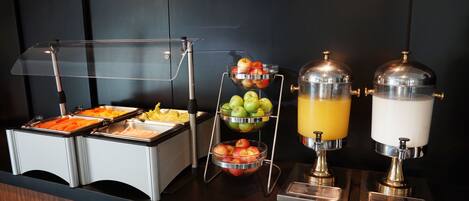 A buffet setup with various food items and beverages.