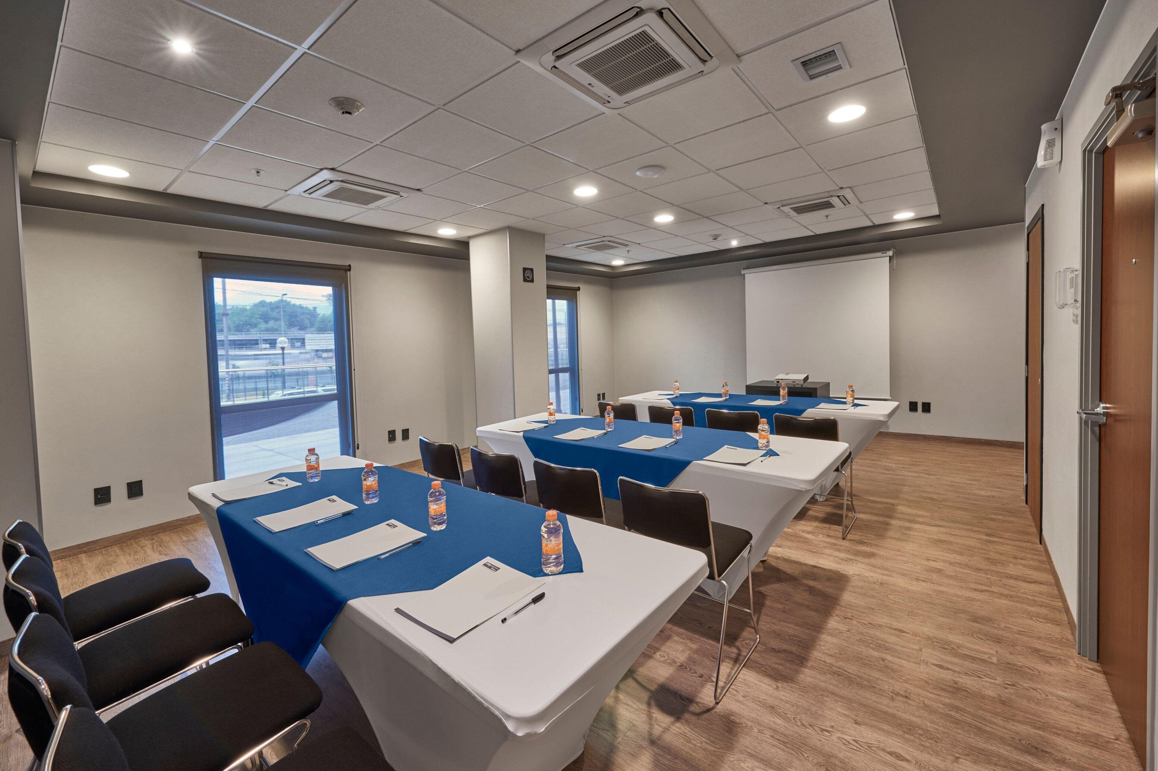 A conference room with tables set up for meetings, equipped with water bottles and nameplates.