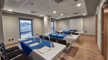 A conference room with tables set up for meetings, equipped with water bottles and nameplates.