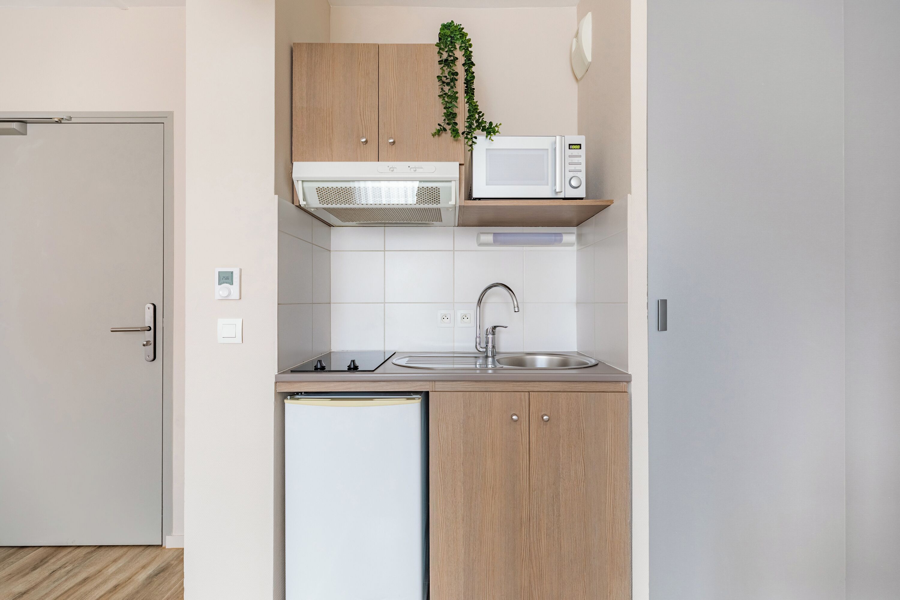 A compact kitchen with a microwave, sink, and dishwasher.
