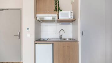 A compact kitchen with a microwave, sink, and dishwasher.