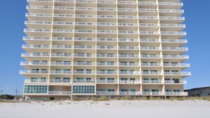 A multi-story hotel with balconies, a beach view, and a sandy ground floor. - Crystal Shores by Wyndham Vacation Rentals (Gulf Shores)