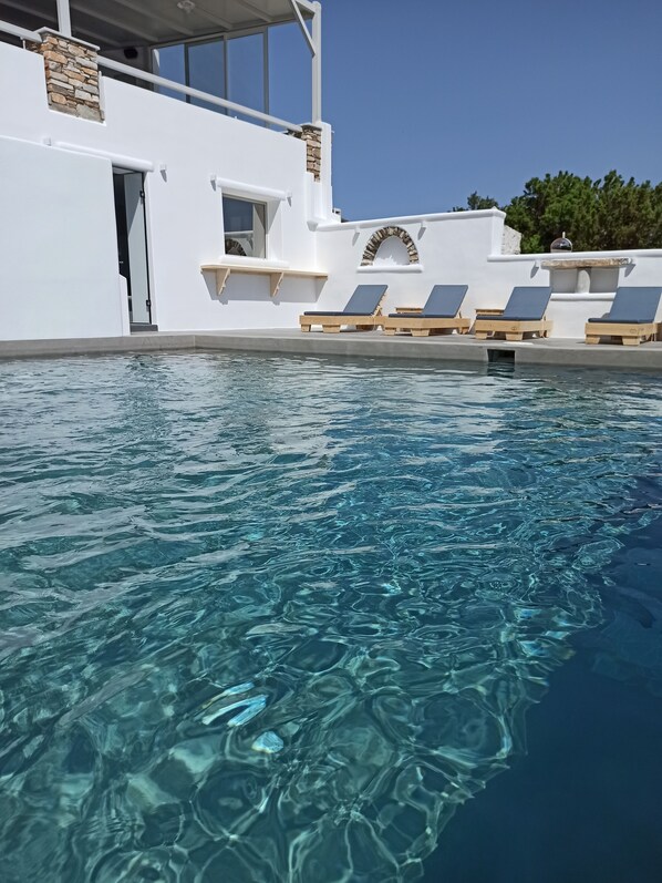 Una piscina al aire libre de temporada, tumbonas