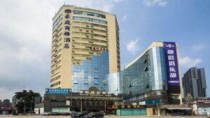 A hotel with a modern facade, multiple floors, and a prominent sign indicating it is a commercial hotel. - Haoting Commercial Hotel - Zhuhai (Zhuhai)