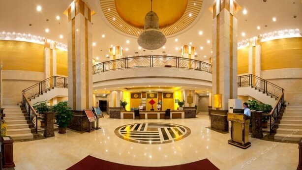 A spacious lobby with a central circular design, a reception desk, and a staircase leading to an upper level. - Haoting Commercial Hotel - Zhuhai (Zhuhai)