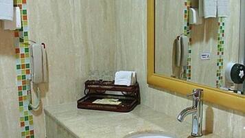A bathroom with a sink, mirror, and a telephone.