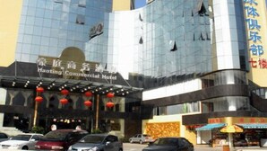 A commercial hotel with a modern glass facade, a visible sign for Haoting Commercial Hotel, and a storefront with a patterned awning. - Haoting Commercial Hotel - Zhuhai (Zhuhai)