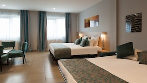 Een hotelkamer met een groot bed, een bureau met stoel en een raam met gordijnen.